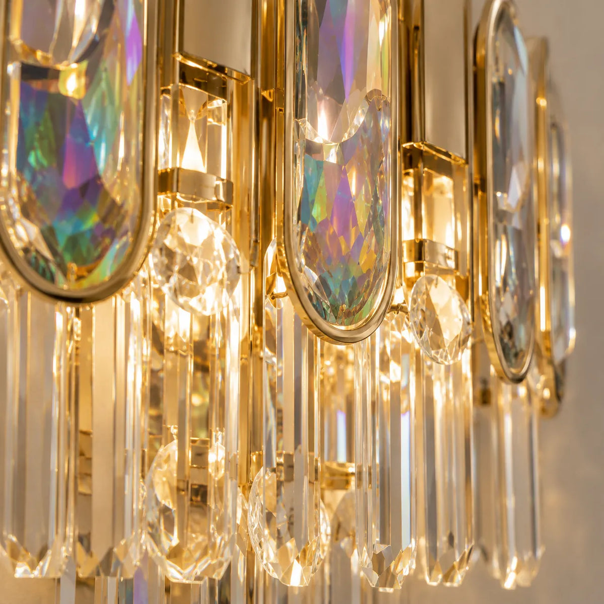 Gros plan sur les reflets irisés du cristal de l'applique murale dorée
