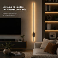 Applique murale salon barre LED allumée près d'un canapé