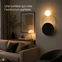 Applique murale salon dorée en verre allumée près d'un canapé
